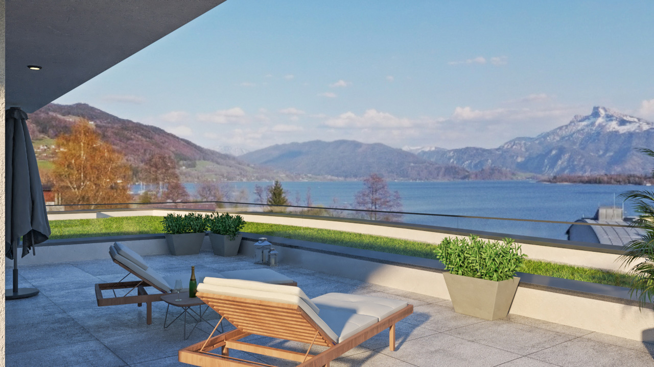 Eine große Terasse mit Liegestühlen. Man hat Blick auf Berge und den See.